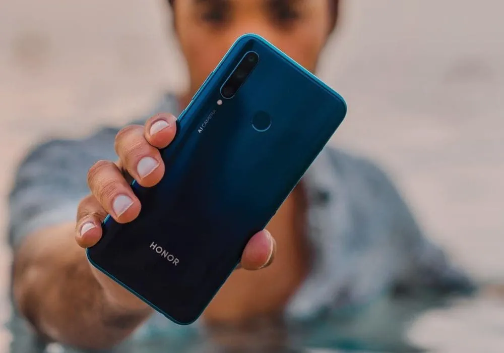 Man standing in water checking his phone