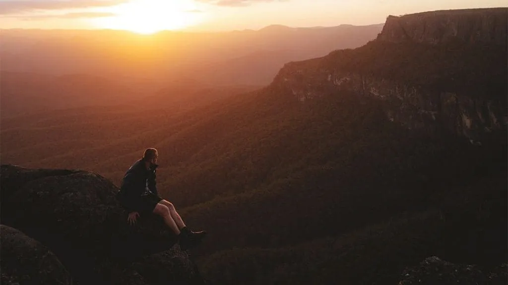man looking out to mountain landscape