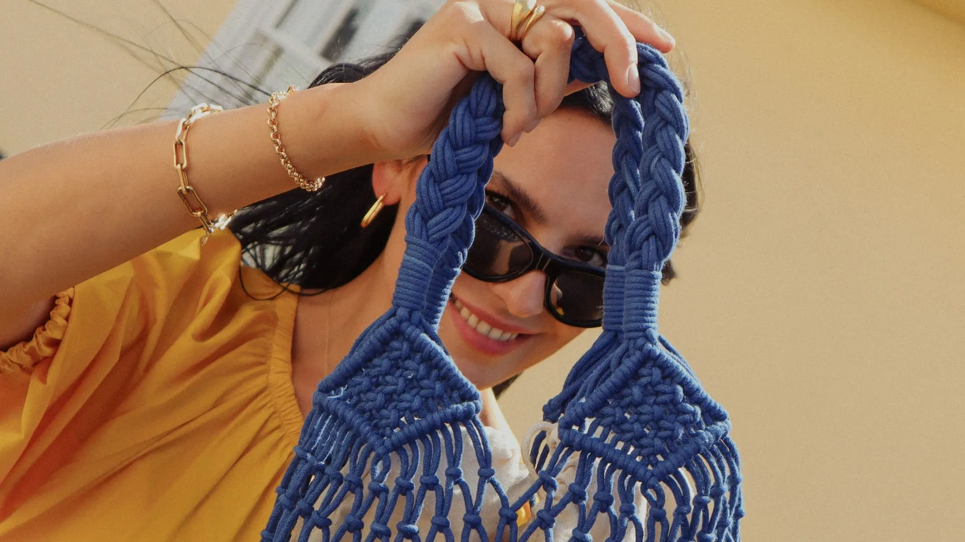 woman holding blue string bag up to face