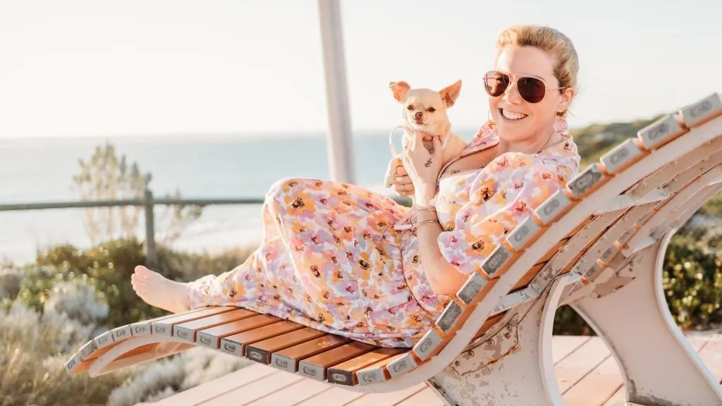 Creator relaxing on a sun lounger with a chihuahua, filming TikTok content