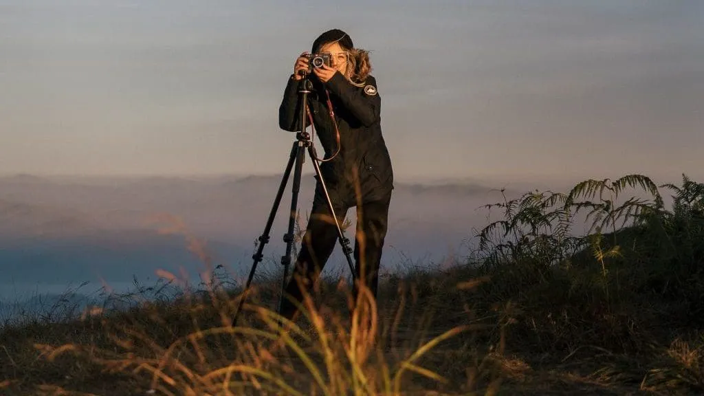 woman using camera on tripod