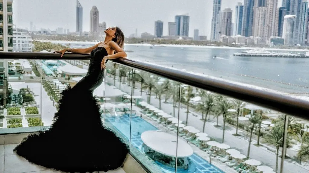 Creator in a black gown photographed on a balcony