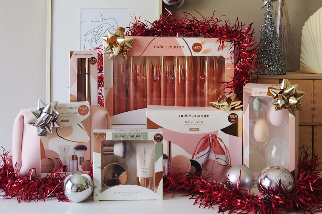 Nude by Nature Christmas gift sets among red tinsel, bows and baubles, styled by @nattdesu