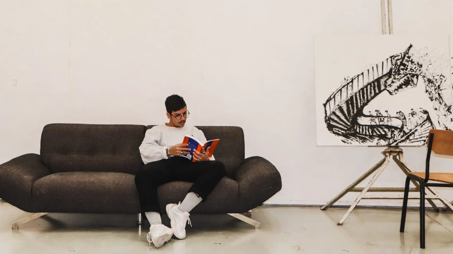 man on couch reading book