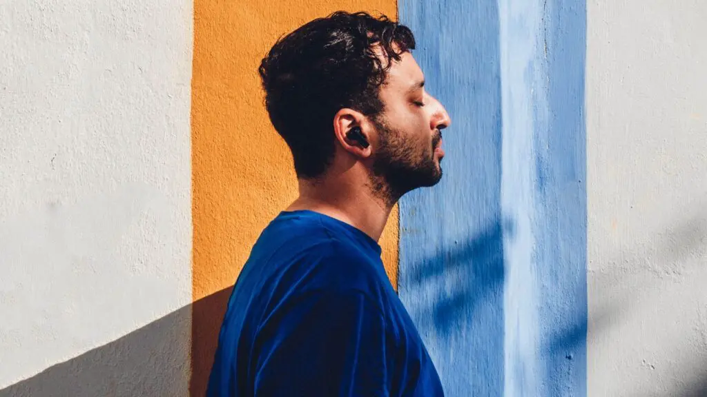 man in front of blue and orange wall