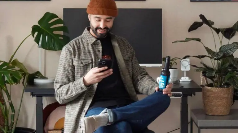 man at desk with a bottle of beer