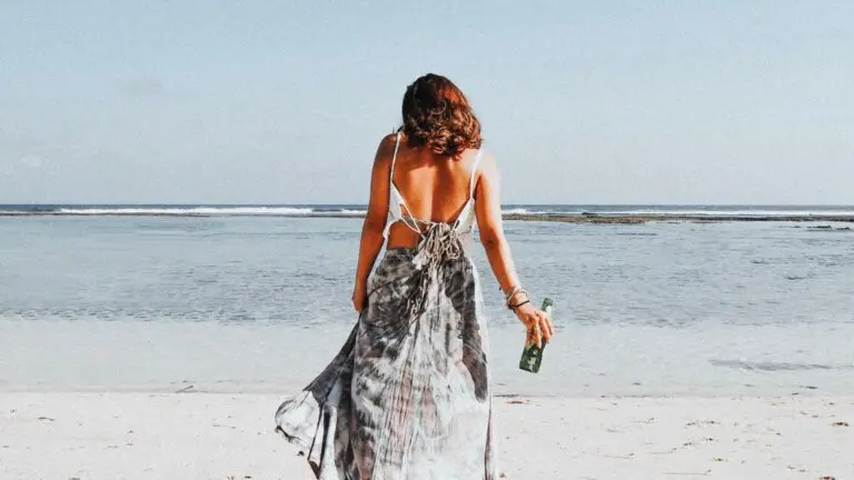 woman holding bottle looking out to sea