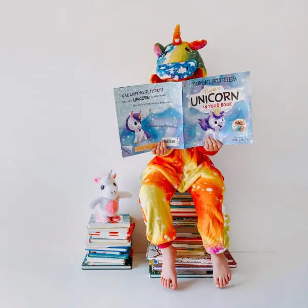 Penguin random house content. Small child reading books.