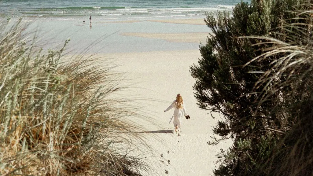 woman walking on beach to sea