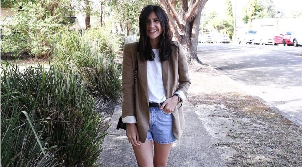 woman in brown blazer and denim shorts