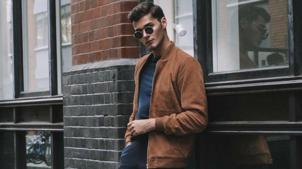 sam gray in brown suede jacket and blue trousers