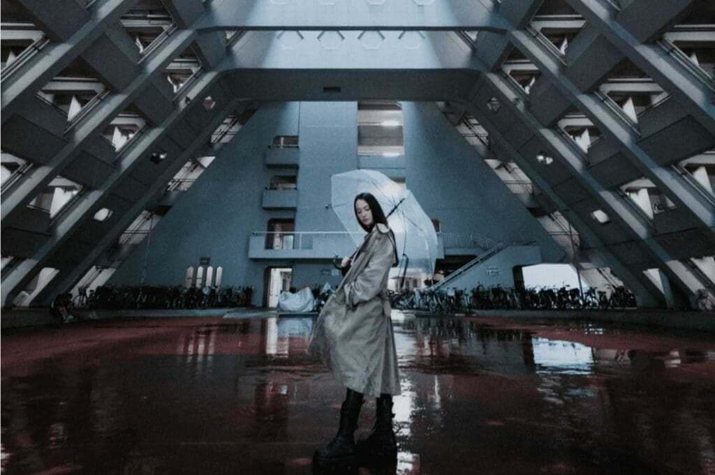 woman in a rain mac in futuristic building