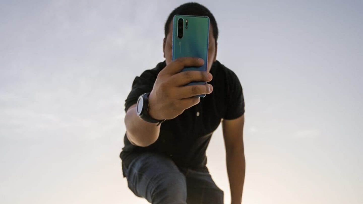 man wearing watch and black t shirt with mobile phone