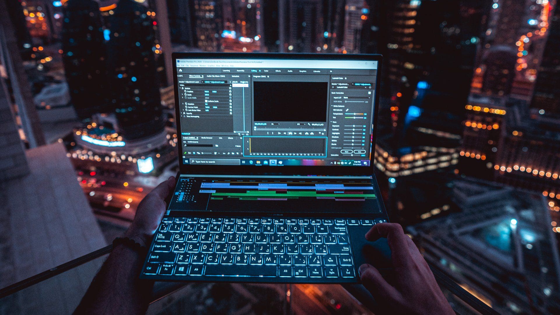 laptop in front of night time city skyline