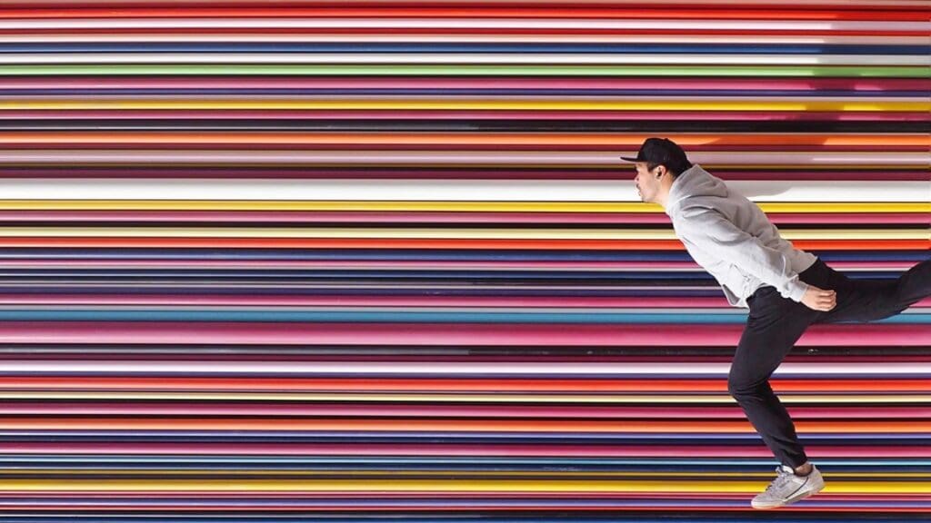 man in front of multi coloured wall