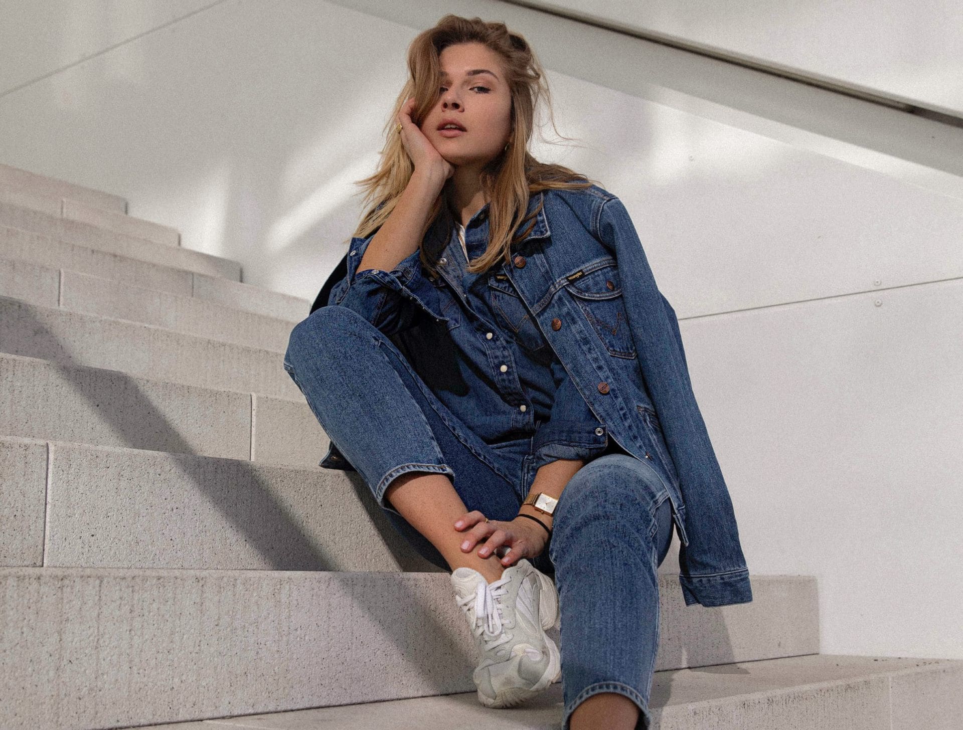 woman in full denim outfit sitting on steps