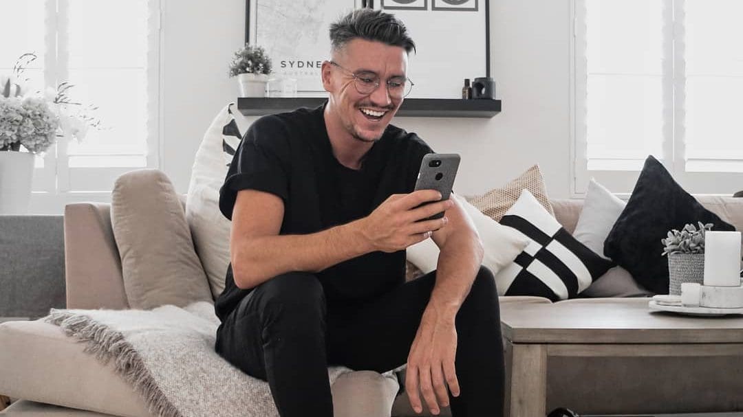 man in black t shirt and black jeans on mobile