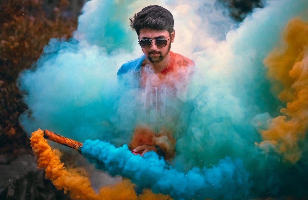 man with colourful smoke bomb