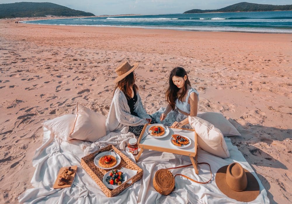 two women on beach having picnic @incyvincyspider
