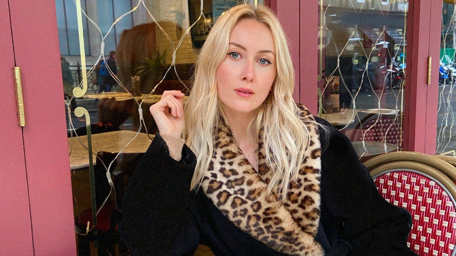 woman in fur coat sitting outside restaurant