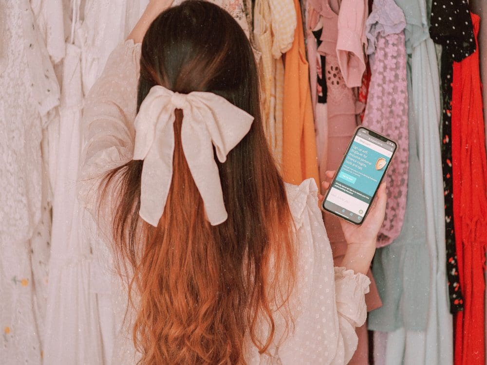 woman shopping for clothes with phone in hand