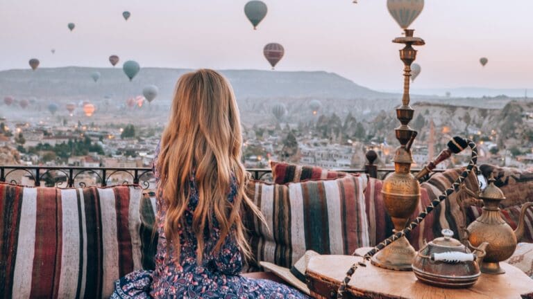 woman on terrace watching hot air balloons