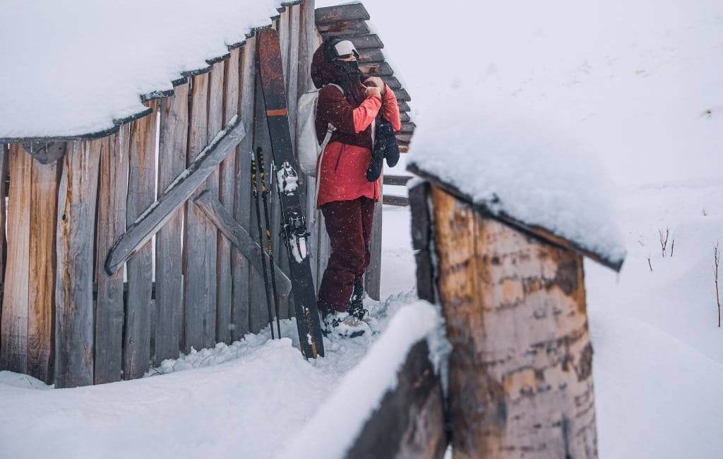 woman skier on snowy ledge