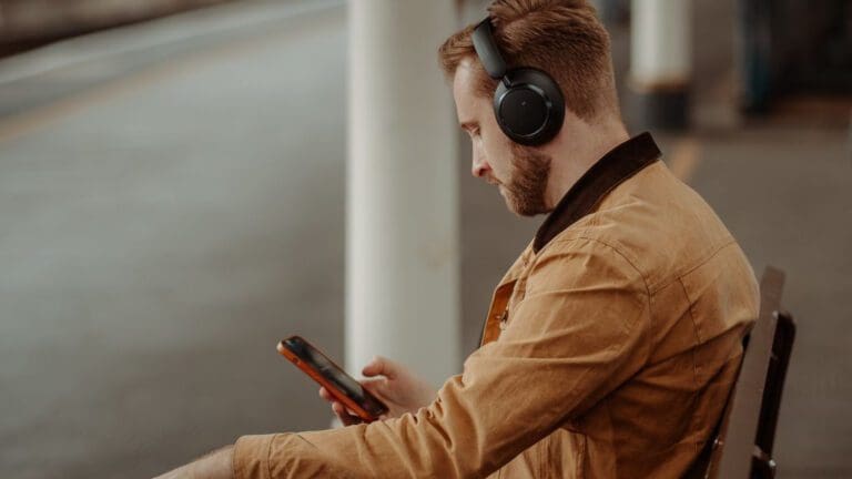 man with headphones on looking at his phone