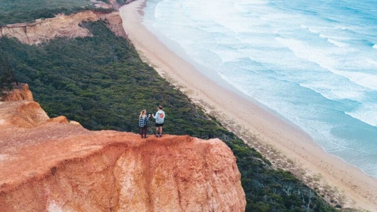 couple on cliff edge over beach