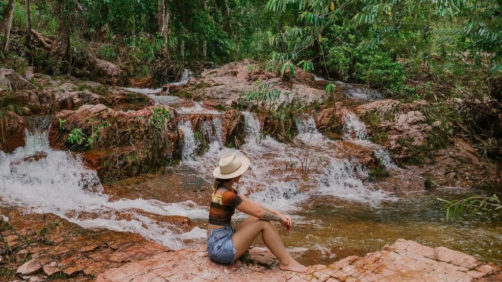 woman sitting in front of a waterfall