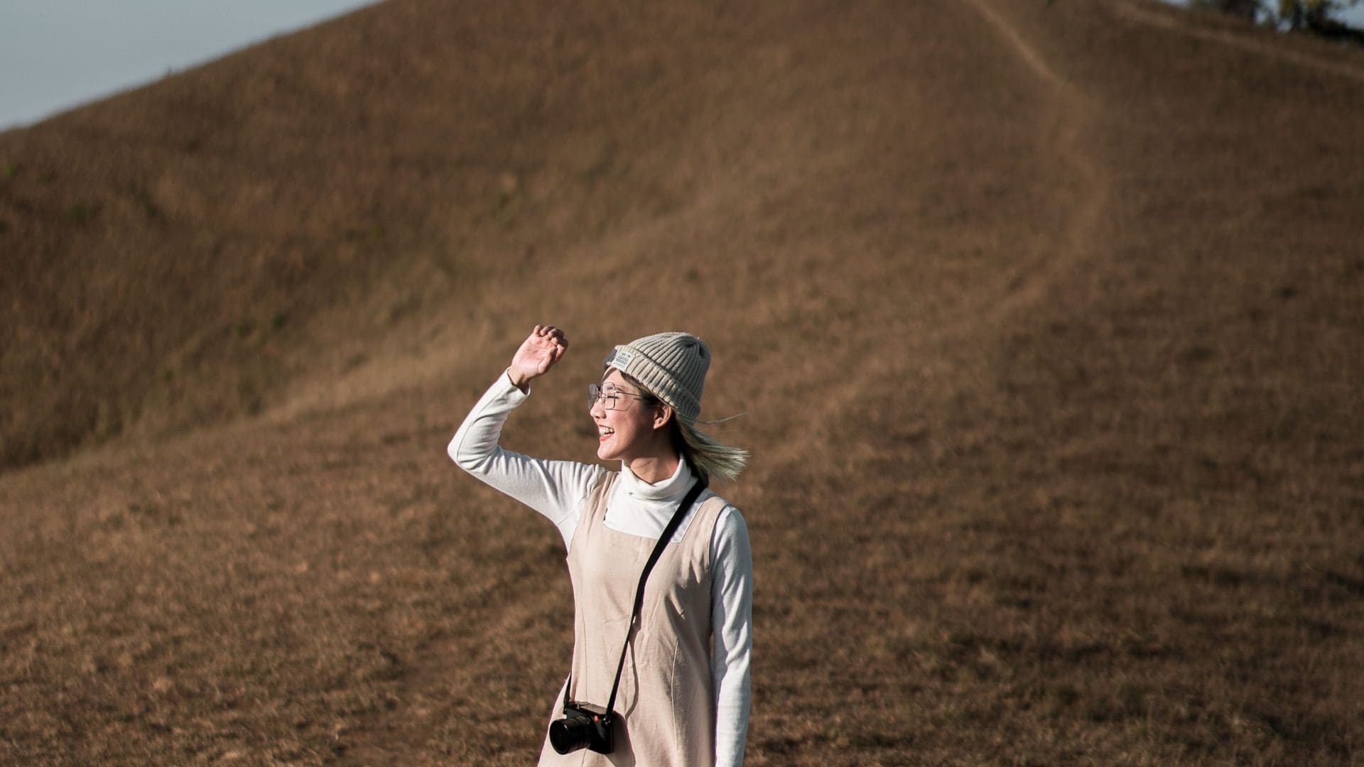 woman on hill with camera round her neck