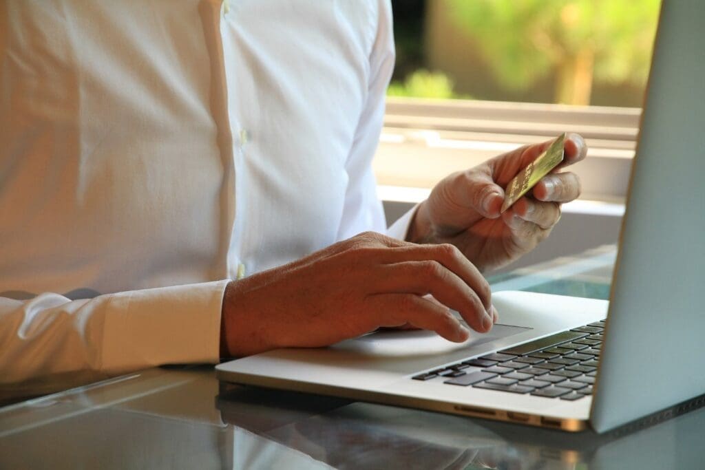 man shopping online with credit card and laptop