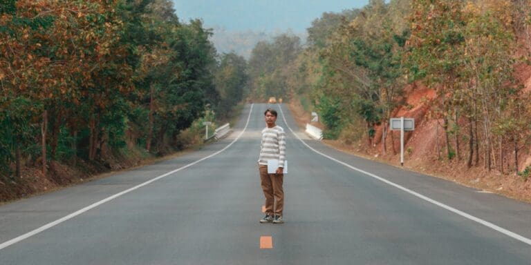 man holding laptop in road