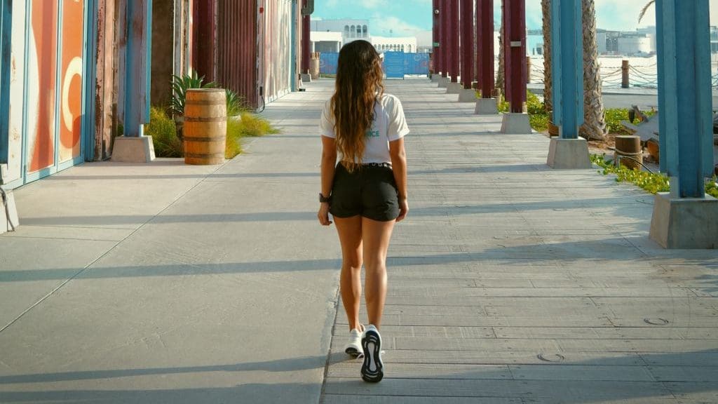 woman walking in white t shirt and black skirt