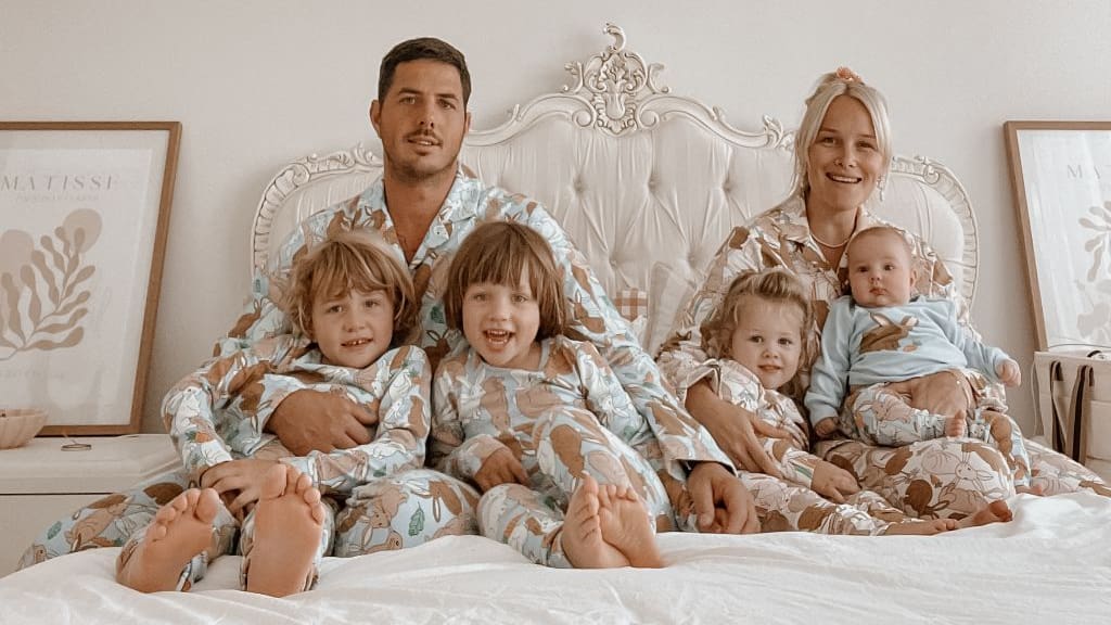 family of six all in matching pyjamas on bed