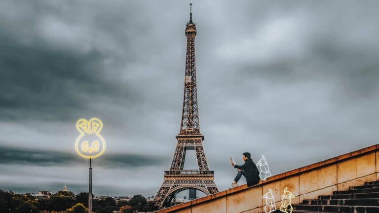 man on phone in front of Eiffel tower