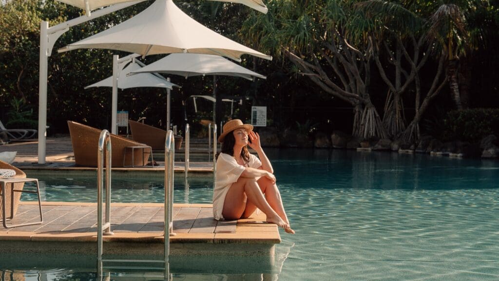 woman sitting on jetty over swimming pool - Accor thecommonwanderer