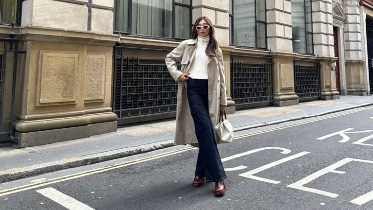 woman wearing heavy knit with beige coat and blue jeans